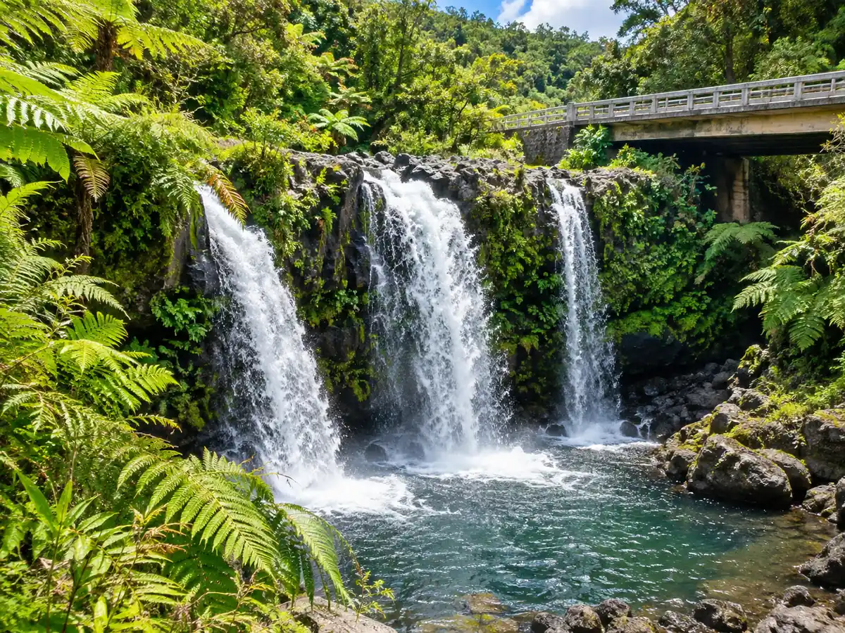Una tripla cascata che si getta in una pozza rocciosa nella verde foresta pluviale