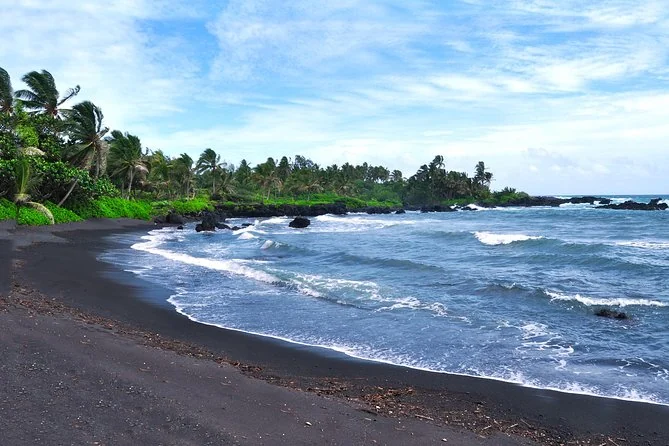 Una playa de arena negra con oleaje suave